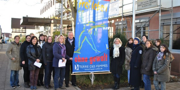 Zeigten gemeinsam Flagge gegen Gewalt an Frauen: Zahlreiche Lampertheimerinnen, Apothekerin Jutta von Amende (r. neben d. Fahne), die Gleichstellungsbeauftragte Sonja Niederhöfer (2. l. n. d. Fahne) und Bürgermeister Erich Maier. Foto: Benjamin Kloos