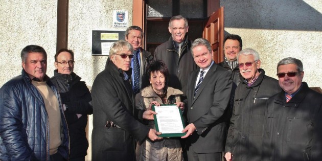 Sonnenschein, blauer Himmel und ein warmer Geldregen wie ein Weihnachtsgeschenk – diese Gabe des Landes Hessen, von Landrat Matthias Wilkes überbracht, kam bei den Beteiligten gut an. Den Förderbescheid halten Bürgermeisterin Bärbel Schader, Landrat Matthias Wilkes (rechts) und Ortsvorsteher Hans-Georg Gött. Ortsbeiratsmitglied Peter Hölzel (links) wie auch arbeiten im Arbeitskreis Dorferneuerung mit. Bei der Übergabe dabei waren Erster Stadtrat Walter Wiedemann (von rechts), Stadtverordnetenvorsteher und früherer Ortsvorsteher Ewald Stumpf, Arbeitskreismoderator Stefan Lösch, Stadtrat Herbert Röchner, Architekt Werner Ofenloch, Helmut Dollak und Ortsbeirat Peter Hölzel, der wie Ewald Stumpf im Arbeitskreis aktiv ist. Foto: Hannelore Nowacki