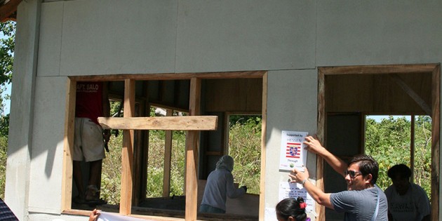 Dank „Hessen hilft" entstehen die ersten Häuser: Menschen in Guiwanon bringen Unterstützer-Logos am neuen Haus an. Foto: oh