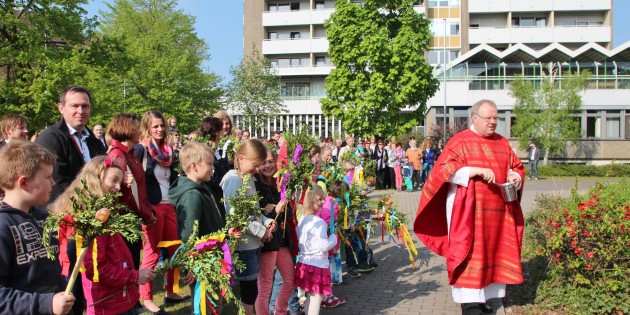 An der Kreuzigungsgruppe hinter der Kirche Mariä Verkündigung begann der Familiengottesdienst am Palmsonntag mit der Weihe der Palmsträuße. Foto: Hannelore Nowacki