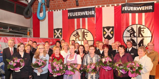 Die Geehrten, ihre Partnerinnen, die offiziellen Funktionsträger aus der Lokalpolitik, aus dem Kreis Bergstraße und der Feuerwehr kamen zum abschließenden Gruppenbild zusammen. Als Wertschätzung für ihre Unterstützung erhielten die Partnerinnen einen Blumenstrauß. Foto: Hannelore Nowacki