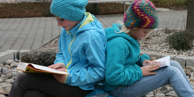 Kaufen und loslesen - So lautete wohl das Motto der beiden Bücherwürmer, die es sich nach ihrem erfolgreichen Besuch auf dem 18. Bücherflohmarkt der Martin-Luther-Gemeinde gleich auf dem Kirchenvorplatz gemütlich gemacht haben. Foto: Eva Wiegand