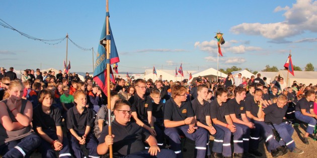 Die 1.200 Teilnehmer des 50. Kreiszeltlagers der etwa 90 Jugendfeuerwehren im Kreis Bergstraße hatten sich zur Eröffnung in großer Runde mit ihren bunten Wimpeln versammelt. Foto: Hannelore Nowacki