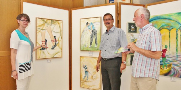 Angelika Keck präsentiert im Rathausfoyer einen Teil ihrer Bilderreihe zum Thema Golf, die noch bis zum 2. September zu sehen ist. Bürgermeister Felix Kusicka (Mitte) zeigte sich begeistert, zumal Biblis mit einem Golfpark in Wattenheim aufwarten kann. Foto: Hannelore Nowacki