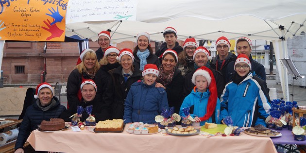 Die beteiligten Kinder und Jugendliche des weihnachtlichen Tafelprojekts gemeinsam mit ihren Betreuern auf dem Wochenmarkt. Foto: Sigrid Samson
