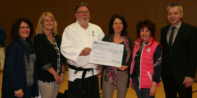 Iris Tremel, Sozialarbeiterin im Frauenhaus Bensheim nahm mit großer Freude den symbolischen Scheck von Klaus Fritz, Vorsitzender des 1. Judo-Clubs in der Sporthalle der EKS entgegen. Foto: Eva Wiegand
