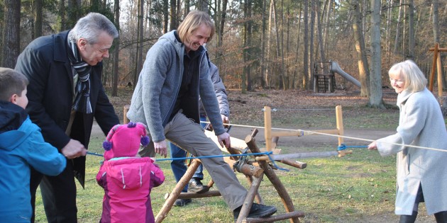 Weihten das Walderlebniscamp auf besondre Art und Weise ein: Carola Biehal, Ortsvorsteherin von Neuschloß (r.) sägte gemeinsam mit Bürgermeister Gottfried Störmer (l.) unter mithilfe aller Anwesenden einen Ast durch. Natur- und Wildnispädagoge Mirko Klein (2.v.r.) freut sich über das Engagement und hofft auf reges Interesse. Foto: Benjamin Kloos