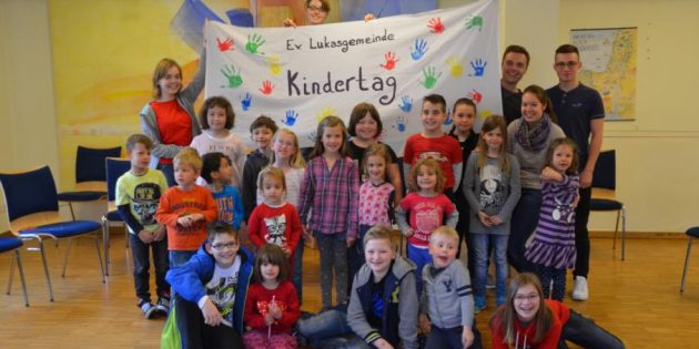 Die Kinder des Kindertages mit dem Betreuerteam vor dem neuen Kindertags-Plakat, dass am vergangen Samstag gestaltet wurde. Foto: oh