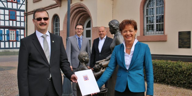 Die hessische Europa-Ministerin Lucia Puttrich überreichte Bürgermeister Felix Kusicka im Beisein des Ersten Beigeordneten Herbert Ritzert (hinten rechts) und des Landtagsabgeordneten Alexander Bauer den Zuwendungsbescheid für das 30-jährige Partnerschaftsjubiläum mit der französischen Gemeinde Gravelines in Höhe von 1.500 Euro - symbolträchtig vor der bronzenen Gurkenfrau mit Kind am Rathaus. Foto: Hannelore Nowacki