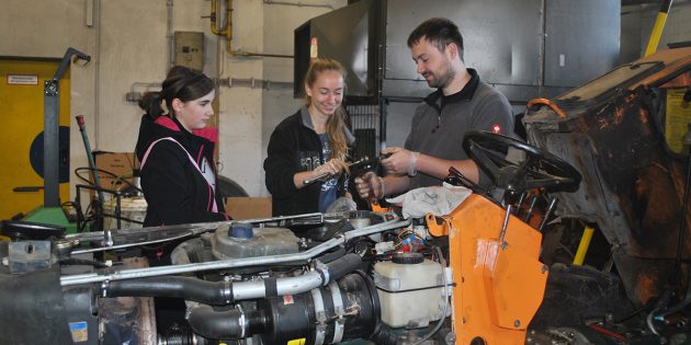 Paul Veith von den Technischen Betriebsdiensten erläuterte am Girls-/Boys-Day Nina und Aileen (v.r.), wie man einen Traktor repariert. Foto: Benjamin Kloos