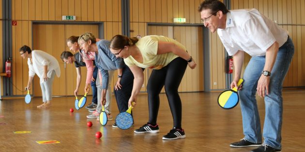 In zwei Reihen aufgestellt, haben die Kursteilnehmerinnen bei dieser Life-Kinetik-Übung alle Hände voll zu tun, gleichzeitig komplexe Denkaufgaben zu erfüllen und koordiniert jeweils ein Bein zu heben. Foto: Hannelore Nowacki