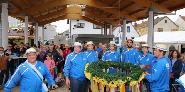 Kerwevadder Damiano Brucato hat den Kerwekranz traditionsgemäß mit einer ganzen Flasche Wein geweiht und beim mundartlichen Reimen auch bedacht, dass zur Kerwe nicht immer die Sonne scheint. „Ob Regen und Wind dich auch umrunden, bringt die Kerwe uns frohe Stunden“. Foto: Hannelore Nowacki
