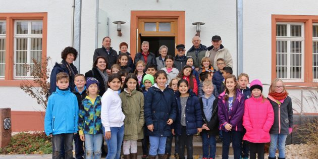 Wie war „Schule früher“? Um dieses Thema geht es gerade im Sachkundeunterricht der dritten Klasse der Astrid-Lindgren-Schule. Die Mitglieder der Arbeitsgruppe Ortsgeschichte Bobstadt führten die Kinder anschaulich durch das heutige „Alte Rathaus“, das früher auch Schule war. Auf dem Vorplatz ging es auch um die viel ältere Bobstädter Ortsgeschichte. Foto: Hannelore Nowacki