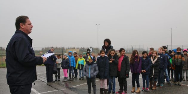 Die Astrid-Lindgren-Schule war bei der Räumungsübung komplett geräumt und alle Klassen hatten sich auf dem Sammelplatz vor der Sporthalle übersichtlich aufgestellt. Im Nieselregen hielt Rupert Getrost vom Brandschutzteam der Freiwilligen Feuerwehr Bobstadt nur eine kurze Ansprache. Foto: Hannelore Nowacki