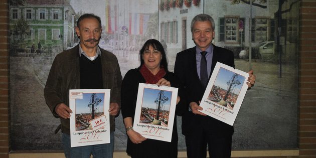 Frisch aus dem Druck erhielt Bürgermeister Gottfried Störmer (r.) den Lampertheimer Kalender 2017 aus der Hand von Margit Karb, Vorsitzende des Heimat-, Kultur- und Museumsvereins (Mitte), und Drucker Hans-Michael Platz (l.). Foto: Benjamin Kloos