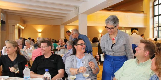 Wein und gute Stimmung gingen bei der Weinprobe eine glückliche Verbindung ein. Pfarrerin Sabine Sauerwein schenkte an diesem Tisch ein. Foto: Hannelore Nowacki