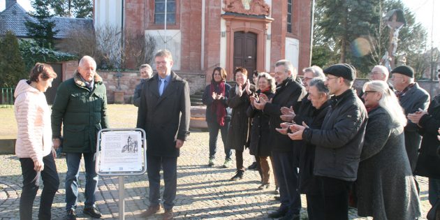 Die Bürgerstiftung Lampertheim, vertreten durch die Vorstandsmitglieder (von links) Elzbieta Liermann, Erich Maier und Ralph Butz übergaben offiziell das neue Schild auf dem Vorplatz der Kirche St. Michael. Foto: Eva Wiegand