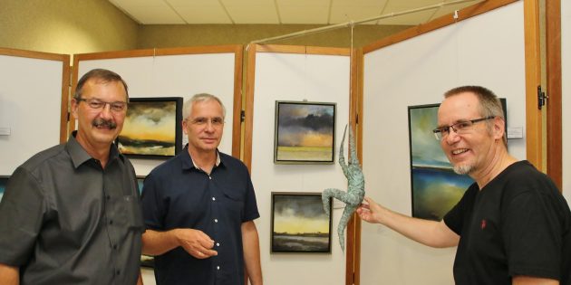 Bürgermeister Felix Kusicka (links) ließ sich von den beiden Künstlern die Werke erläutern – Klaus Odenwald aus Oftersheim (Mitte) hat die Ölbilder gemalt, Rainer E. Rühl gestaltet Plastiken aus verschiedenen leichten Materialien zu Themen, die ihn bewegen. Foto: Hannelore Nowacki