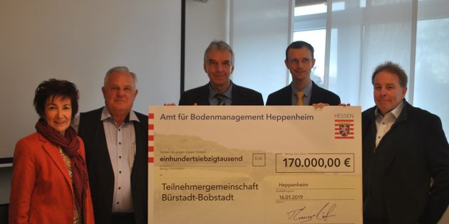 Der Vorsitzender der Teilnehmergemeinschaft von Bürstadt-Bobstadt, Richard Schöcker (2.v.l.) freut sich im Beisein von Bürgermeisterin Barbara Schader (l.) über den Förderbescheid, der ihm durch die Vertreter des Amtes für Bodenmanagement – Amtsleiter Thomas Knöll (Mitte), Onno Diddens (2.v.r.) und Jörg Ritter (r.) – überreicht wurde. Foto: Benjamin Kloos