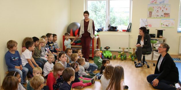 Wald- und Lieder-Oma Monika Britz (links) mit Bürgermeisterin Barbara Schader und Kita-Leiterin Anja Kuhn im Gespräch mit dem Kinderchor der Kita Zwergenwald. Foto: Hannelore Nowacki