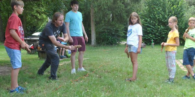 Bei der Waldmeisterschaft hatten die Ferienspaßkinder mächtig Spaß – so auch beim Kiefernzapfenweitwurf, hier demonstriert durch den Waldpädagogen Mirko Klein. Foto: Benjamin Kloos