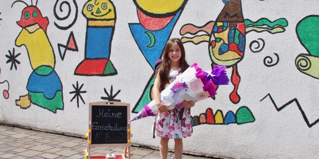 Nora freute sich schon auf den Unterricht am Montag. Zur Einschulungsfeier am Samstag kam die große Schultüte mit. Für das Erinnerungsfoto zeigte Nora ihr strahlendes Lächeln ohne Maske, die sie wegen der Coronaregeln wie ihre Eltern auf dem Schulgelände aufsetzen musste. Foto:  Hannelore Nowacki