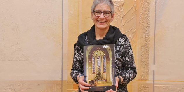 Der festliche Adventskalender der Evangelischen Lukasgemeinde zum Preis von nur 5 Euro birgt interessante Gewinnchancen hinter jedem Türchen. Pfarrerin Sabine Sauerwein verkündete den Verkaufsstart. Foto: Hannelore Nowacki