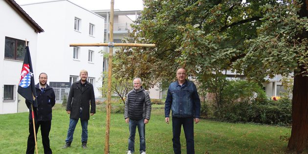 Holzkreuz auf Wiese hinter der Kirche installiert