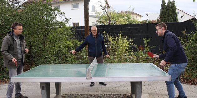 Weihten die neue Tischtennisplatte auf dem Spielplatz „An der Tuchbleiche” ein: Der Erste Stadtrat Jens Klingler (l.) und Sportcoach Marius Schmidt (r.) – sehr zur Freude von Ortsvorsteher Karl-Heinz Berg. Foto: Benjamin Kloos