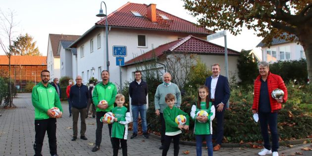 Große Freude über den prominenten Besucher Klaus Schlappner und die gespendeten Fußbälle. Im Bild (von links): Jugendleiter und Trainer Bajram Eleza, Ortsvorsteher Karl Heinz Berg, Sportcoach Marius Schmidt, Klaus Schlappner, Kreisbeigeordneter Karsten Krug und der Erste Vorsitzende der SG Hüttenfeld Bernd Ehret mit drei jungen Fußballbegeisterten. Foto: Hannelore Nowacki