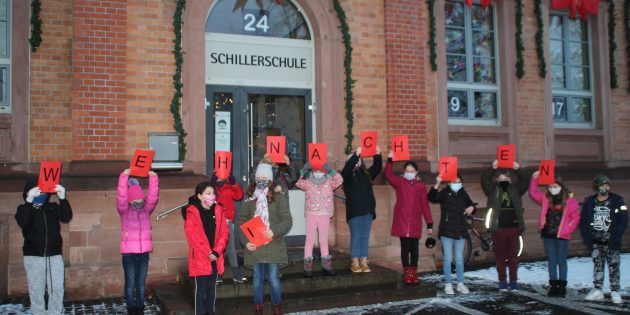 Der erste Schnee fällt und das erste Adventskalendertürchen der Schillerschule öffnet sich. Mit einem kleinen Beitrag zum Auftakt sorgte die Klasse 4a für besinnliche Weihnachtsstimmung. Foto: Eva Wiegand 
