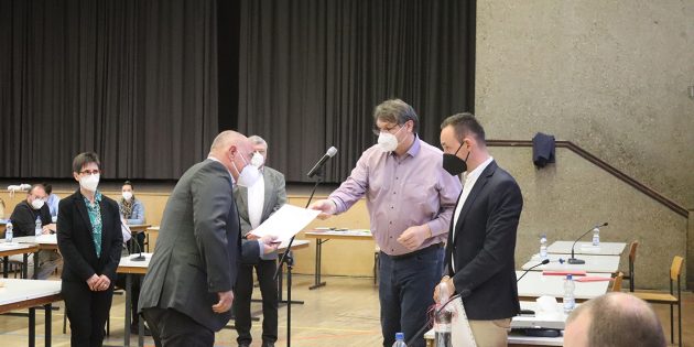 Bürgermeister Volker Scheib überreicht im Beisein des neu gewählten Vorsitzenden der Gemeindevertretung, Konstantin Großmann (r.) die Ernennungsurkunde an den neuen 1. Beigeordneten Herbert Ritzert (l.). Foto: Benjamin Kloos