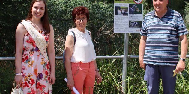 Den Wasservögeln fehlt es in der Naturoase an nichts, sie sollen nicht gefüttert werden. Das steht nun auch groß auf dem neuen Hinweisschild am Teich. Diese Idee von Alois Klüber gefällt auch Bürgermeisterin Barbara Schader und Sonnenbotschafterin Luisa-Marie I. Foto: Hannelore Nowacki