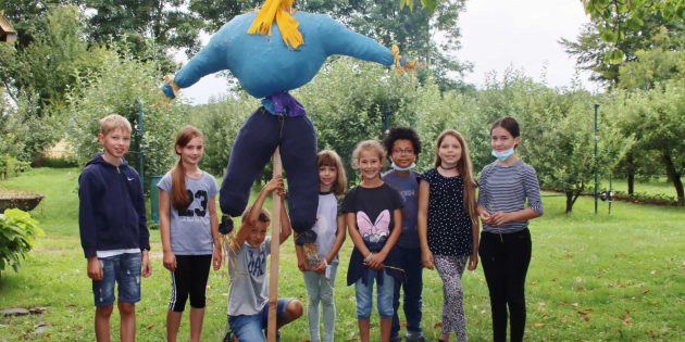 Spaß beim kreativen Arbeiten hatten die Ferienkinder beim Obst- und Gartenbauverein. Die eindrucksvolle Strohpuppe hat das Potenzial Besucher willkommen zu heißen oder als Vogelscheuche zu wirken. Foto: Hannelore Nowacki
