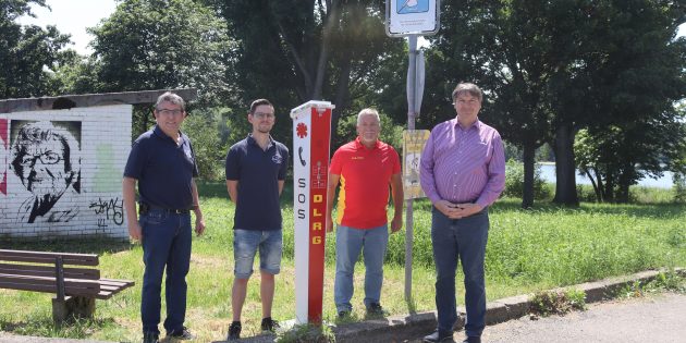 Am Gemeindesee in Biblis wurde eine Notrufsäule installiert – sehr zur Freude von Christian Schäfer, Vorsitzender der Ortsgruppe Biblis, seinem Stellvertreter Daniel Hofmann, Matthias Denner Kreisvorsitzender der DLRG und Bürgermeister Volker Scheib (v.l.). Foto Benjamin Kloos