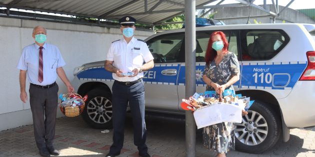 Gabriele (r.) und Peter Hick (l.) überreichten dem Leiter der Polizeistation Lampertheim-Viernheim, Matthias Seltenreich (Mitte) zwei Körper voller Basteleien, die Kinder und Jugendliche in den virtuellen Versammlungen von Jehovas Zeugen gestaltet hatten. Foto: Benjamin Kloos