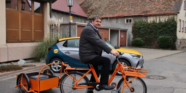 Bürgermeister Volker Scheib stellte das neue Lastenfahrrad für die Gemeindemitarbeiter vor, im Hintergrund das neue, geleaste E-Fahrzeug der Gemeinde Biblis. Foto: Hannelore Nowacki