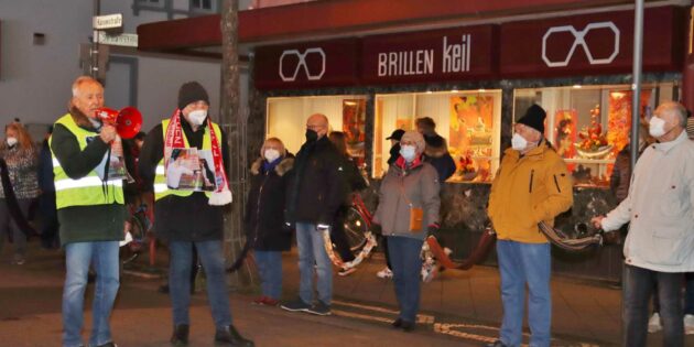 Die beiden Organisatoren der Gegendemonstration, Erich Maier und Hans Linke, hatten die von ihnen angemeldete Menschenkette rund um den Schillerplatz im Blick. Mit Megafon teilte Erich Maier den Teilnehmern den Abschluss gegen 18.45 Uhr mit. Foto: Hannelore Nowacki 