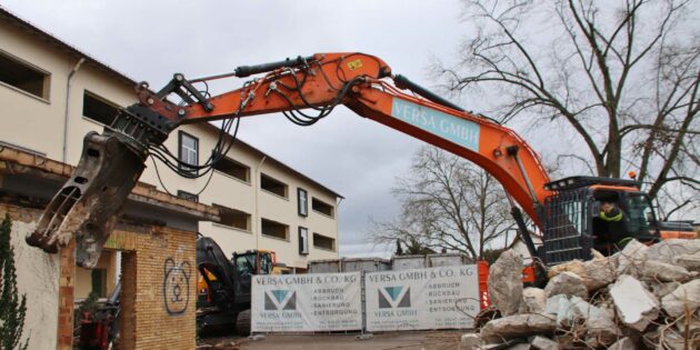 Das entkernte Gebäude wird abgerissen um für den Neubau der Schillerschule Platz zu machen – Landrat Christian Engelhardt setzte zum offiziellen Baggerbiss an. Foto: Hannelore Nowacki
