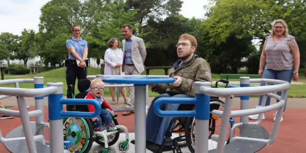 Testfahrer Julian (l.) freute sich sichtlich über das neue Rollstuhlkarussell im Stadtpark Lampertheim – auch Janis Steffan (r.) vom Behindertenbeirat testete das neue „Spielgerät für alle”. Foto: Benjamin Kloos