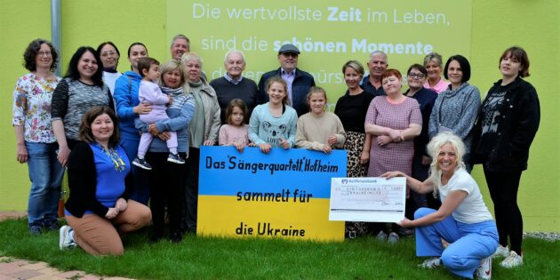 Mit einem im wahrsten Sinne des Wortes großen Spendenscheck kamen Gerd Bauer, Erster Vorsitzender des Sängerquartett Liederkranz, und Schriftführer Klaus Meck (beide Mitte) zum Ukrainetreff im Katholischen Familienzentrum St. Michael. Der Männerchor unterstützt mit 1.000 Euro einen Sprachkurs und Angebote für Kinder für aus der Ukraine Geflüchtete. Foto: Petra Gahabka