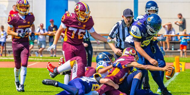 Auch so kann ein Touchdown aussehen. Ein Spieler der Redskins U16 wird von mehreren Hornets niedergerungen und hält im Fall den Ball über die Endzone. Foto: Dirk Wilhelm, Redskins
