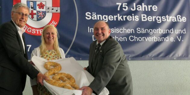Der Kreistagsvorsitzende Joachim Kunkel und die Erste Kreisbeigeordnete des Kreises Bergstraße schenkten dem Sängerkreis einen überdimensionalen Notenschlüssel zum Jubiläum. Rechts SKB-Vorsitzender Heinz Ritsert. Foto: oh