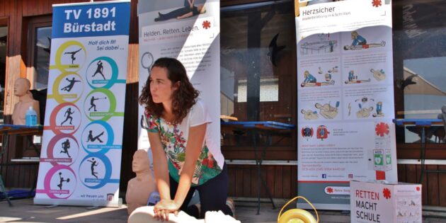 Schulungsleiterin Johanna Ziegler erklärte: Nicht länger als zehn Sekunden prüft man, ob der Mensch noch lebt, dann muss sofort mit der Herzdruckmassage begonnen werden, solange bis die professionellen Retter den Patienten übernehmen. Wenn vorhanden, unterstützt der Defibrillator die Wiederbelebung. Foto: Hannelore Nowacki