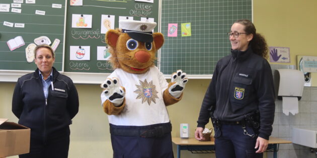 Kinderkommissar Leon stattetet gemeinsam mit dem KOMPASS-Team Christina Wegerle (r.) und Katja Sen (l.) den Erstklässlern einen Besuch ab und überreichte die Broschüre „Sicherer Schulweg” – so wie in der Klasse 1 a der Schillerschule. Foto: Benjamin Kloos