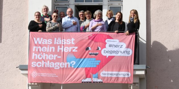 Herzbegegnung - Dekanatsmitarbeitende mit dem Großbanner am Heppenheimer Haus der Kirche. Foto: oh