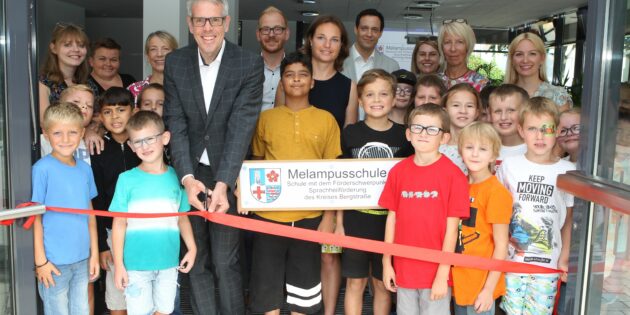 Symbolischer Start ins neue Schuljahr: Landrat Christian Engelhardt (4.v.l.) und Schulleiterin Katharina Schnee (6.v.l.) mit ihrem Team sowie die Betriebsleitung des Eigenbetriebs Schule und Gebäudewirtschaft Johannes Kühn (5.v.l.) und Simon Menden (7.v.l.) mit Schülerinnen und Schülern der Bergsträßer Schule mit Förderschwerpunkt Sprachheilförderung. Foto: oh
