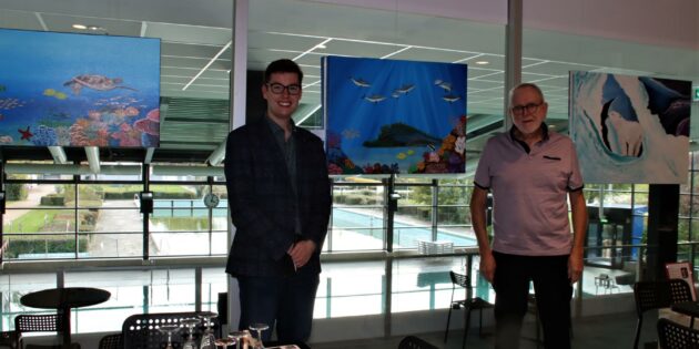 Der Geschäftsführer der Biedensandbäder Marius Schmidt begrüßte die Gäste zur Vernissage mit den Bildern von Martina Rausch im Hallenbadcafé. Hans Schader (rechts) sprach für die erkrankte Künstlerin. Foto: Hannelore Nowacki