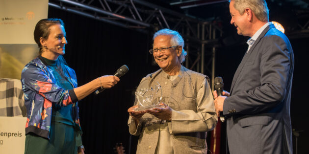 Stiftungsratsvorsitzender Matthias Wilkes (r.) überreichte Muhammad Yunus den Karl Kübel Preis. Links im Bild Moderatorin Julia Tzschätzsch. Foto: Karl Kübel Stiftung / Thorsten Gutschalk