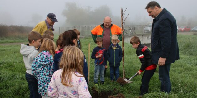 Fachwart Thomas Brecht hatte ein Auge auf die Pflanzaktion, Bürgermeister Volker Scheib hatte schon geschaufelt. Nun machten sich die Kinder motiviert an die Arbeit. Foto: Hannelore Nowacki